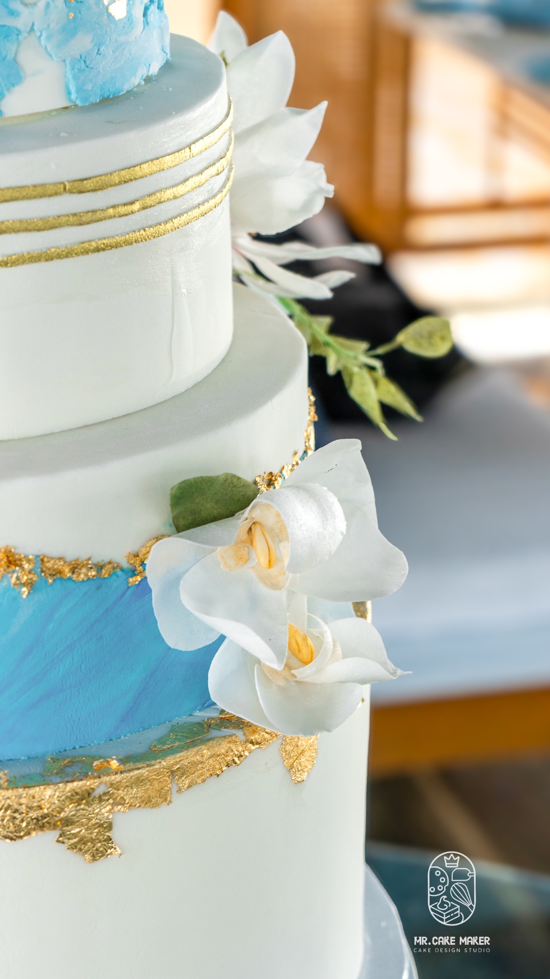 Close-up of blue marble fondant and gold leaf detailing on Mr. Cake wedding cake