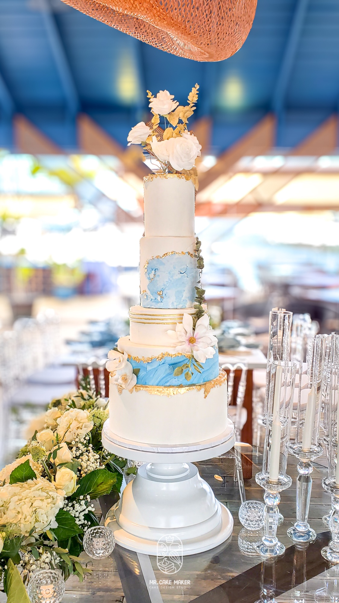 Five-tier wedding cake with blue marble and gold leaf at Juan Dolio beachfront venue